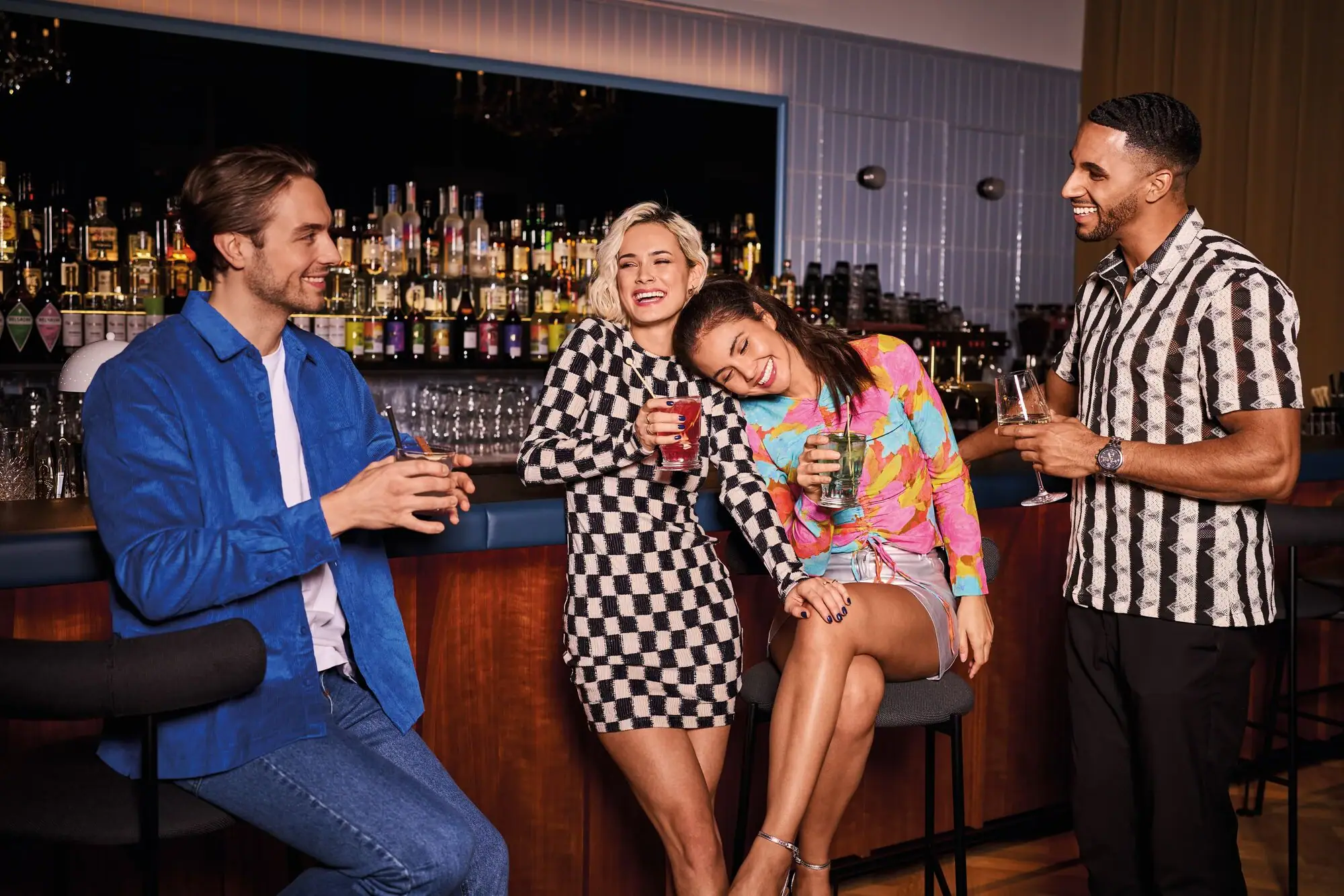 Eine Gruppe von Menschen sitzt lächelnd an einer Bar.