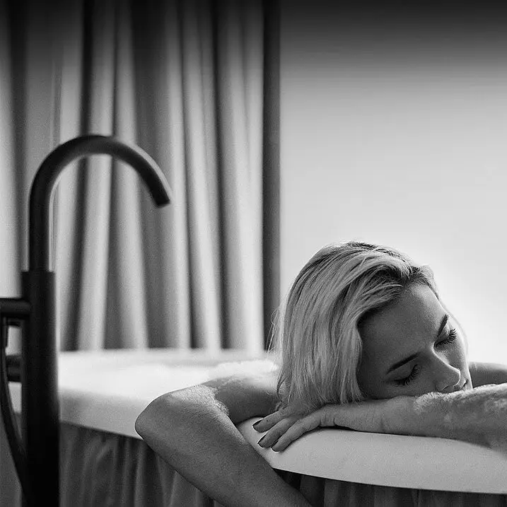 Baden bad Gastein Eine Frau in einer Badewanne lehnt auf dem Rand und entspannt.