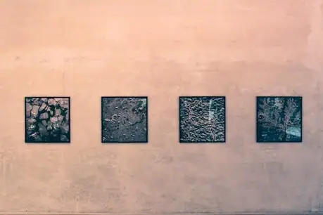 Bildergalerie Vier Schwarz-Weiß-Fotos hängen an einer beigen Wand.