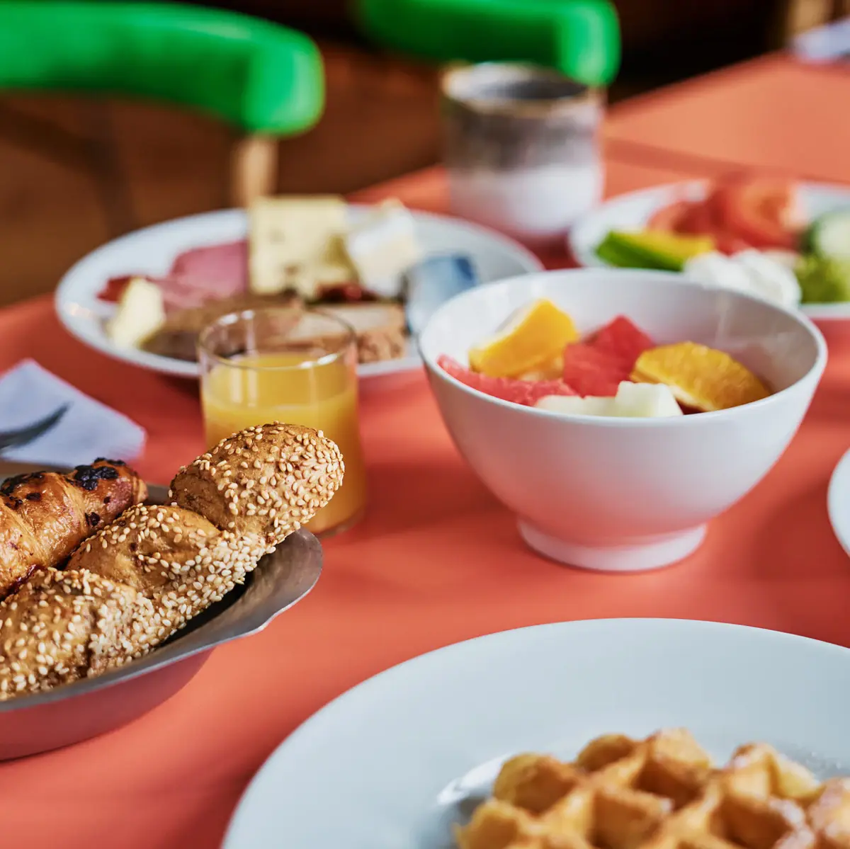 Frühstückstisch Auntie Heidi Ein Frühstückstisch mit Speisen wie Obst, Brot, Eiern und Orangensaft.