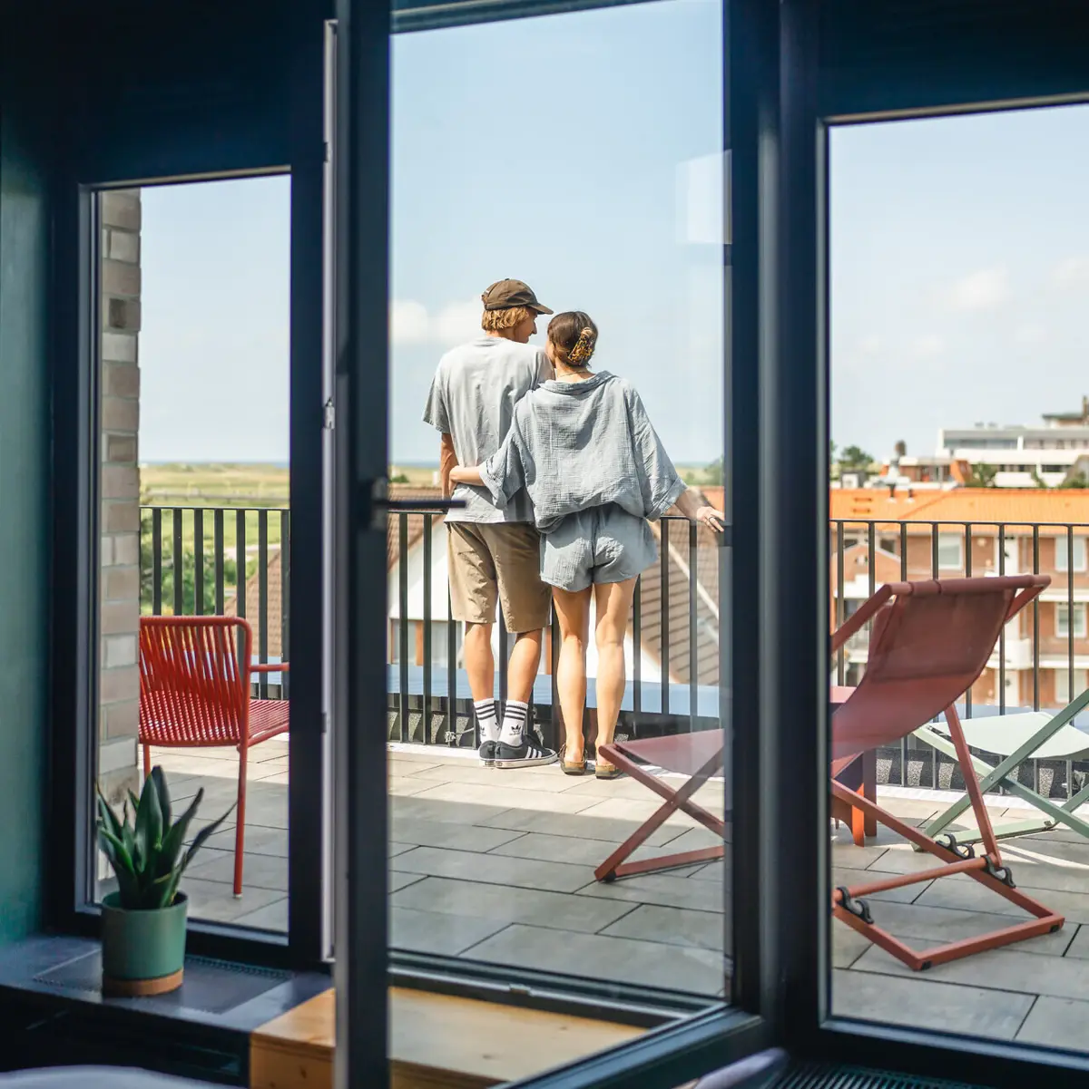 Zimmer St. Peter-Ording Eine Frau und ein Mann stehen auf einem Balkon und genießen die Aussicht.