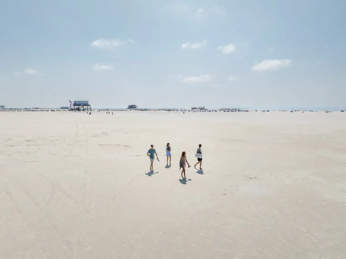 Strand St. Peter-Ording Eine Gruppe von Menschen spaziert am Strand.
