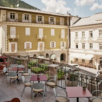 Terrasse Urban Nature Bad Gastein Eine Terrasse mit mehreren Stühlen und Tischen.