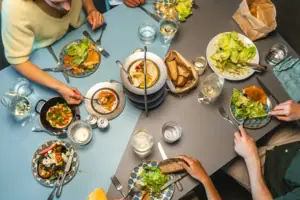 Auntie Clara Eine Gruppe von Menschen beim Essen an einem Tisch.