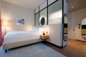 Juniorsuite Straubinger Platz Schlafzimmer mit Bett und Spiegel