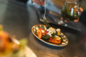 Teller mit Essen Eine Person hält eine Gabel über einem Teller mit Essen.