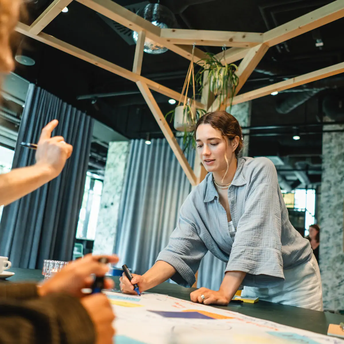 Woman writing on paper at a table indoors.