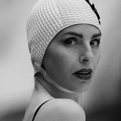 Badekultur Eine Frau mit Badekappe schaut in die Kamera.