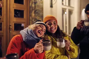 Glühweintrinken Eine Gruppe von Frauen hält Tassen.