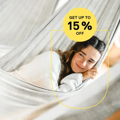 Low Season Deal Eine lächelnde Frau liegt in einer Hängematte.