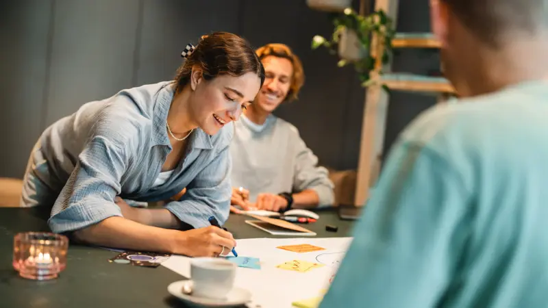 Workshop St. Peter-Ording Eine Frau schreibt etwas auf ein Post-It in einem Workshop.