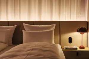 Suite mit Balkon oder Terrasse Ein Bett mit Kissen und einer Lampe.