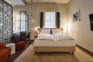 Juniorsuite Schlafzimmer mit Bett und Stuhl.