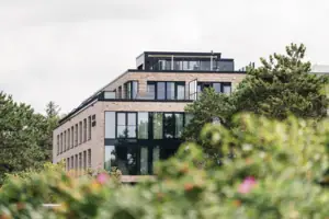 Urban Nature St. Peter-Ording Ein Gebäude mit Bäumen im Hintergrund.