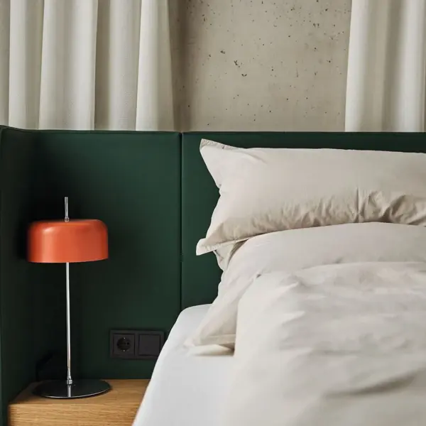 Zimmer Bad Gastein Ein Bett mit einer orangenen Nachttischlampe daneben.