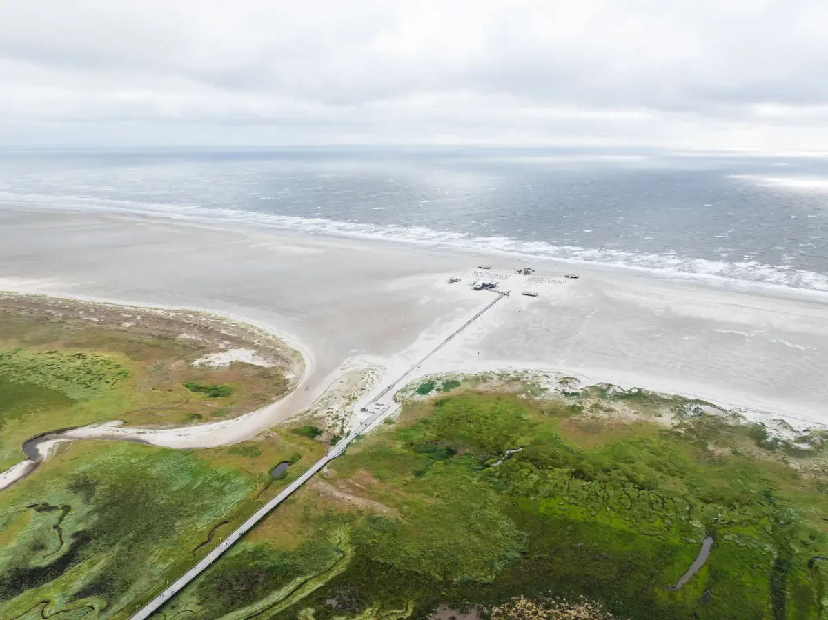 St. Peter-Ording Küste Der Strand von St. Peter-Ording mit der Seebrücke , die über die Salzwiesen zum Meer führt.