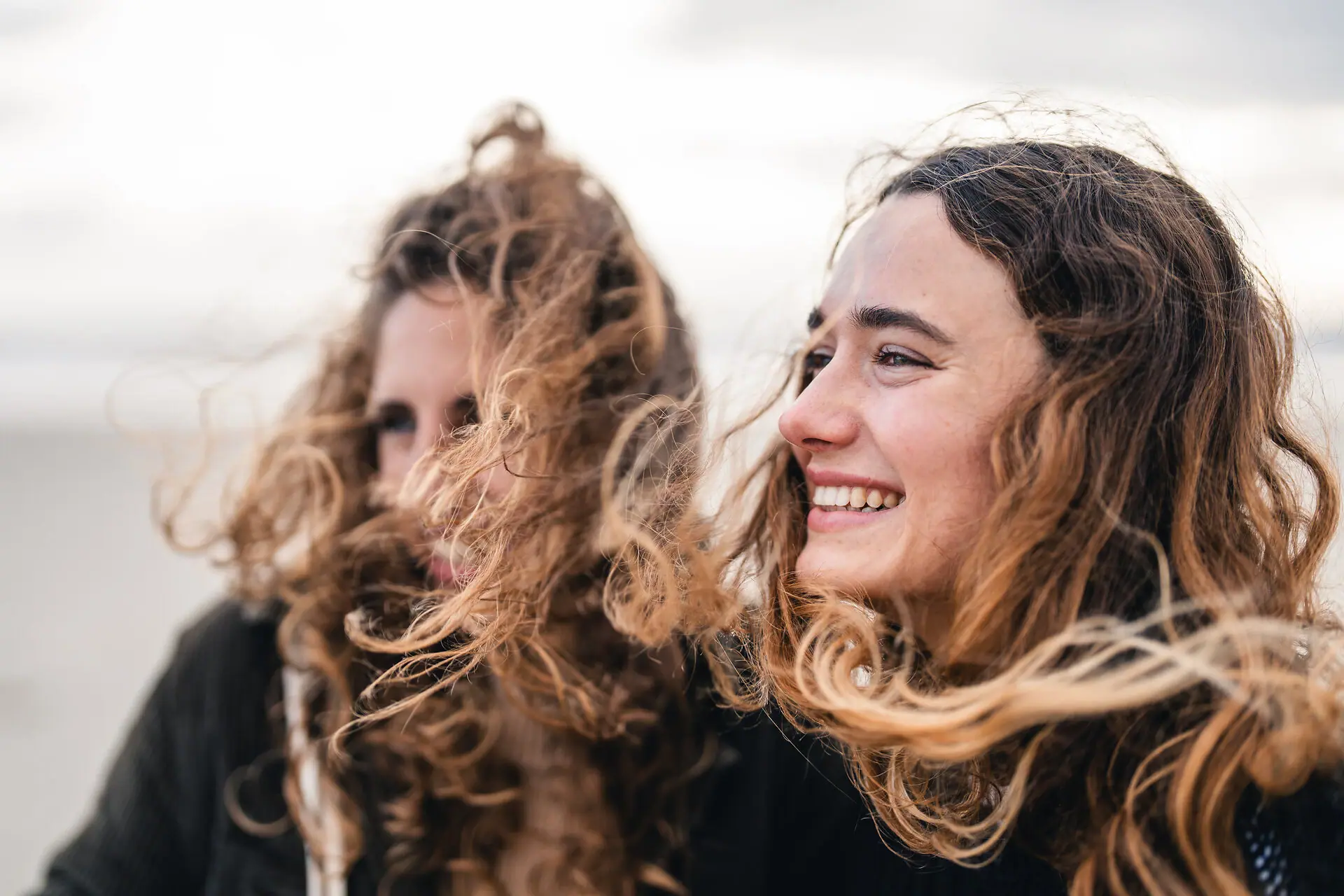 Frauen am Strand Eine Frau mit vom Wind verwehten Haaren.