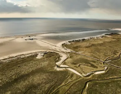 Salzwiesen St. Peter-Ording Die Salzwiesen in St. Peter-Ording mit Wolken am Himmel und Küstenlinie.