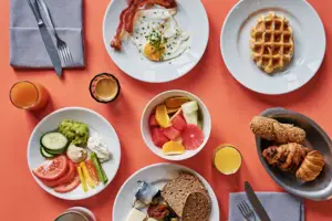 Frühstückstisch Ein Tisch mit Tellern voller Essen und Getränken.