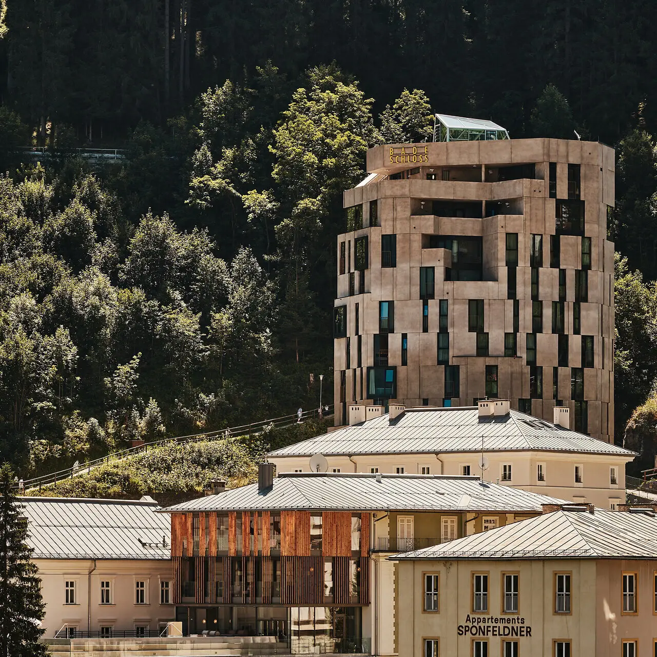 Urban Nature Bad Gastein Badeschloss Das Urban Nature Hotel Bad Gastein von außen mit den Bergen im Hintergrund.