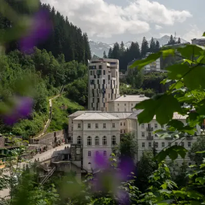 Urban Nature Bad Gastein Badeschloss Alpine house in Bad Gastein at sunrise, set against rugged mountain scenery.