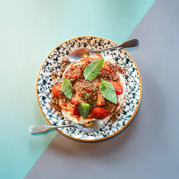 Teller Auntie Clara Restaurant Ein Tellergericht von oben fotografiert mit Tomaten und Basilikum.