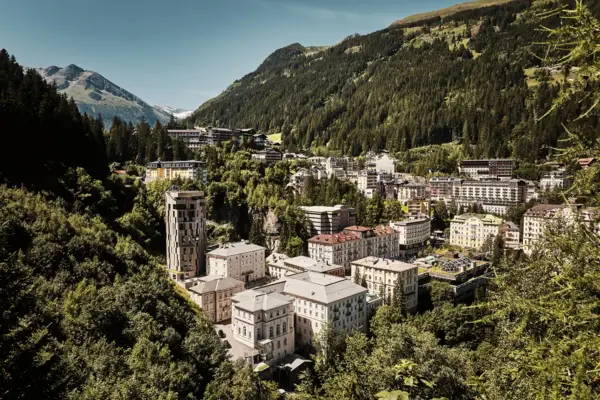Urban Nature Bad Gastein Eine Stadt in den Bergen mit Häusern und einer bewölkten Himmel.