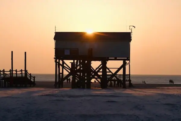 Sonnenuntergang SPO Ein Haus auf Stelzen am Strand von St. Peter-Ording bei Sonnenuntergang.