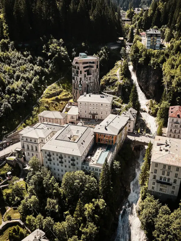 Hotelensemble am Straubingerplatz in Bad Gastein Luftaufnahme des Hotelensembles in Bad Gastein mit modernem Turm, historischen Gebäuden und Pool, eingebettet in grüne Berglandschaft