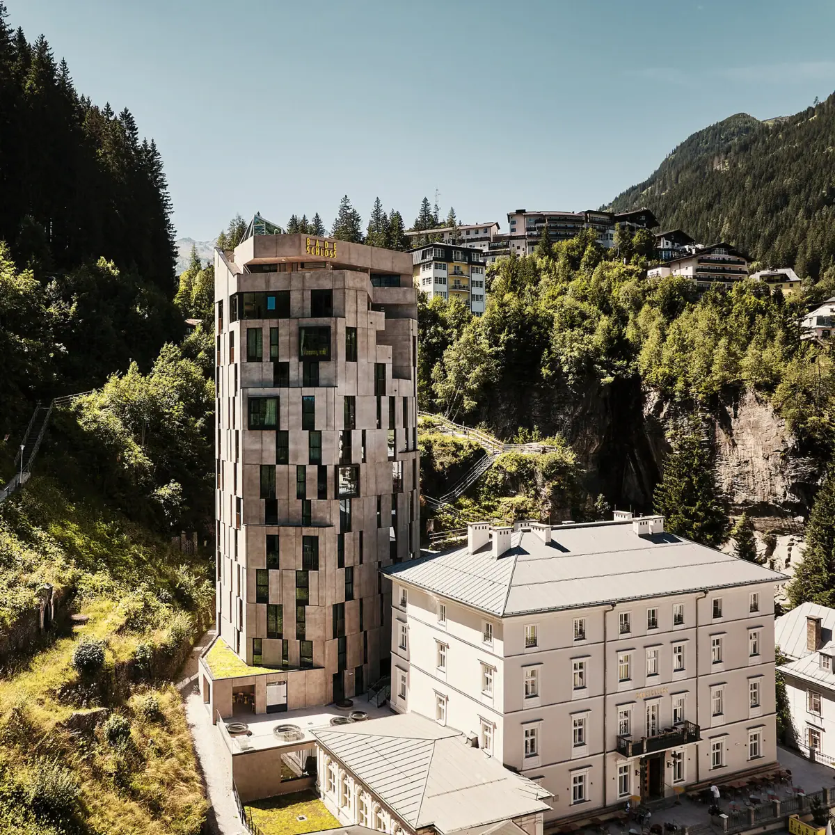 Urban Nature Bad Gastein Das Urban Nature Hotel Bad Gastein von außen mit den Bergen im Hintergrund.