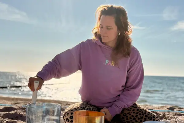 AK Feldkmap Eine Frau sitzt auf einer Decke am Strand.