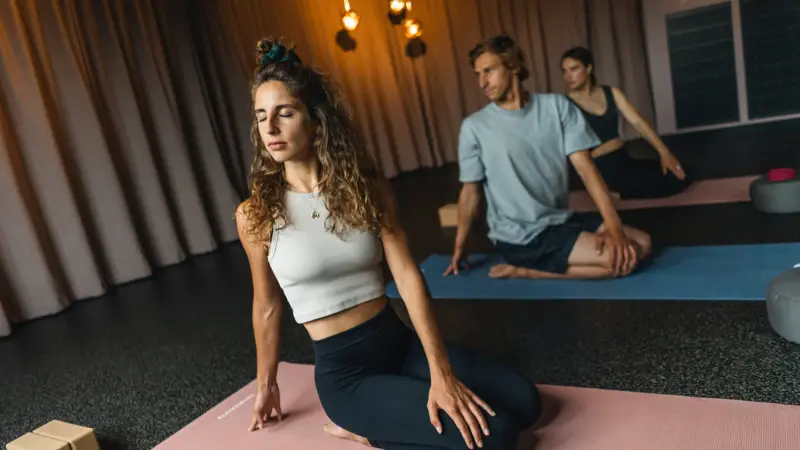 Yoga Urban Nature St. Peter-Ording Drei Personen entspannen beim Yoga machen auf Matten und halten die Augen geschlossen.