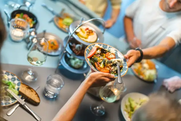 Auntie Clara Restaurant St.Peter-Ording Auf einem Tisch im Auntie Clara Restaurant St.Peter-Ording stehen viele Teller und Vorspeisen in der Mitte, die sich eine Gruppe von Personen teilt.