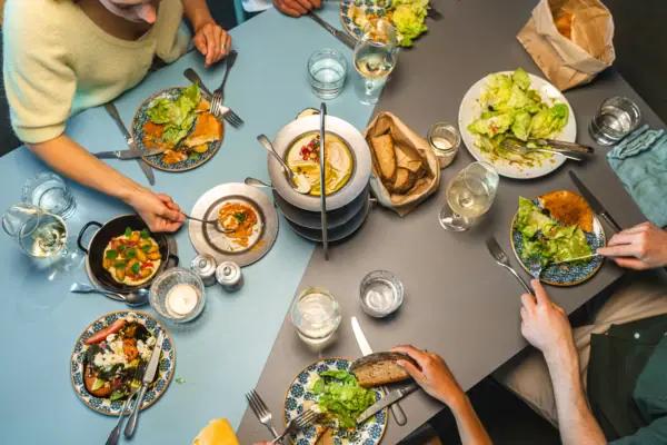 Auntie Clara Eine Gruppe von Menschen beim Essen an einem Tisch.