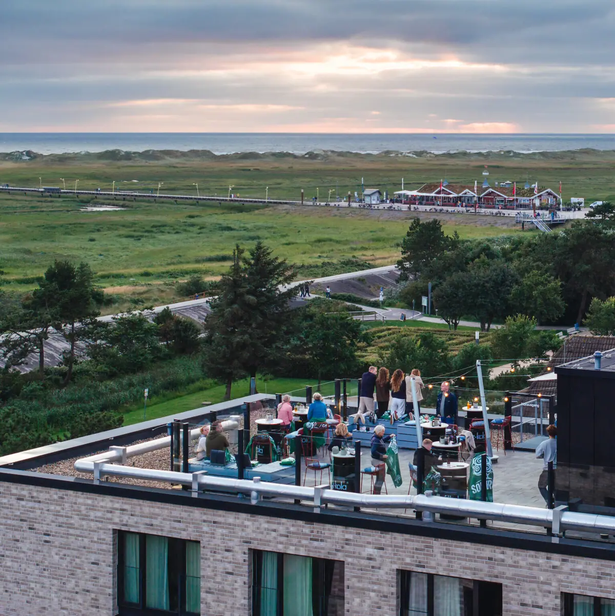 Rooftop Bar Urban Nature Hotel SPO Menschen stehen auf der Rooftop-Bar vom Urban Nature Hotel St. Peter-Ording.