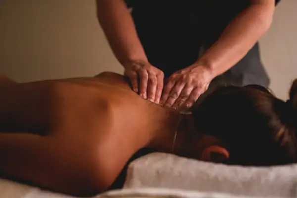 Treatments im Urban Nature St. Peter-Ording Eine Person liegt auf einer Liege und erhält eine Rückenmassage.