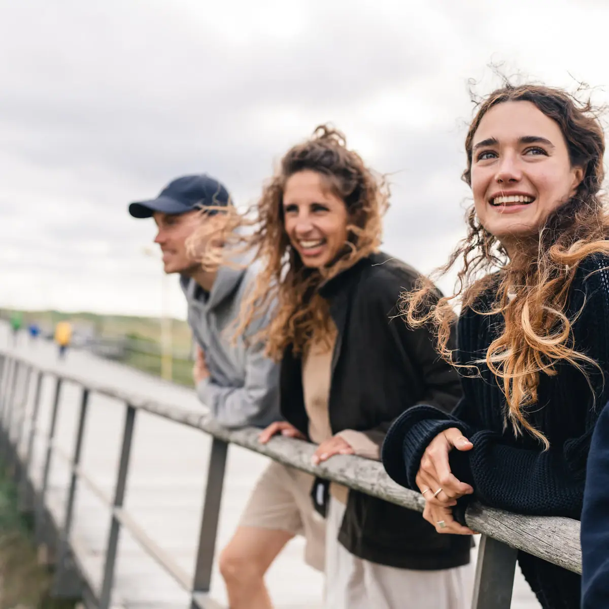 People St. Peter-Ording Drei Personen stehen in St. Peter-Ording auf der Seebrücke und lächeln.