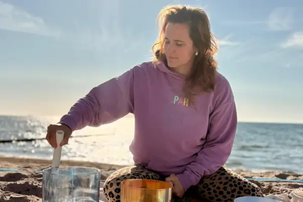 AK Feldkamp Frau sitzt auf einer Decke am Strand.