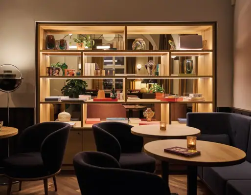 Separee in der Schlossbar im Badeschloss Bad Gastein Stilvoller Lounge-Bereich im Urban Nature Hotel Bad Gastein mit Regal, Vasen, Kerzenlicht und gemütlichen Sesseln