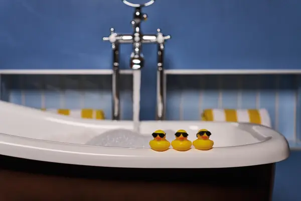 Badewanne Drei Quitescheenten stehen auf dem Rand von einer Badewanne.