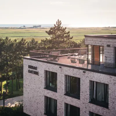 Urban Nature St. Peter-Ording Das Urban Nature Hotel in St. Peter-Ording mit einer großen Dachterrasse von außen fotografiert.