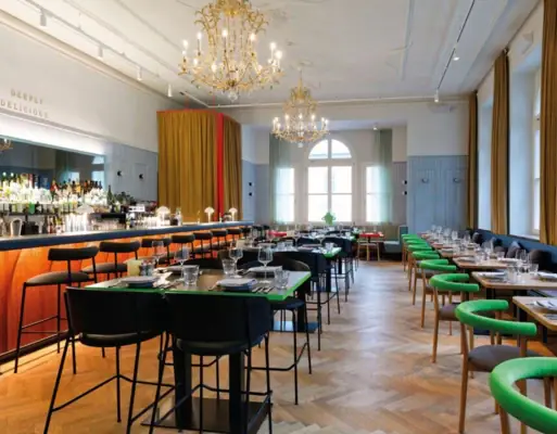 Restaurant Auntie Heidi im Urban Nature Hotel Bad Gastein Stilvolles Restaurant mit eleganter Bar, Kronleuchtern, langen Tafeln und modernem Design