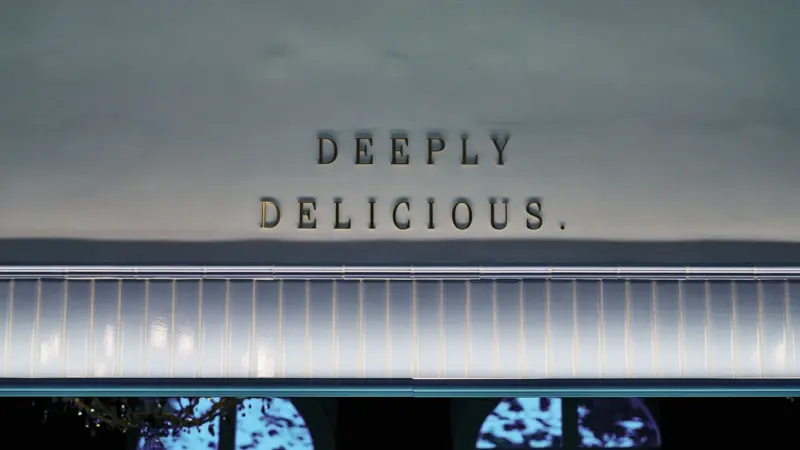 Deeply Delicious An einer Wand hängen die Buchstaben Deeply Delisious.