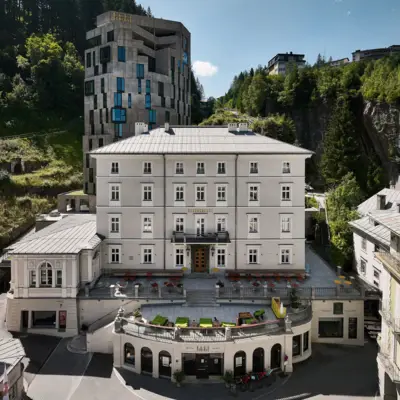 Hotel in Bad Gastein Badeschloss Alpine house in Bad Gastein at sunrise, set against rugged mountain scenery