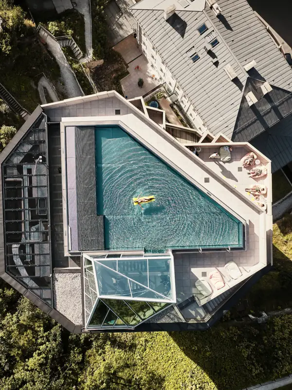 Rooftop-Pool Urban Nature Bad Gastein Ein schmales Gebäude mit einem Rooftop-Pool von oben fotografiert.