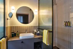 Juniorsuite Badezimmer mit rundem Spiegel und Waschbecken