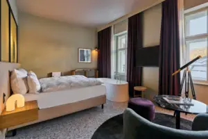 Juniorsuite Straubinger Platz Ein Zimmer mit Bett, Badewanne und violetten Vorhängen.