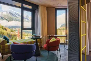 Suite mit Balkon oder Terrasse Ein Zimmer mit Blick auf Berge und eine Stadt durch ein großes Fenster.