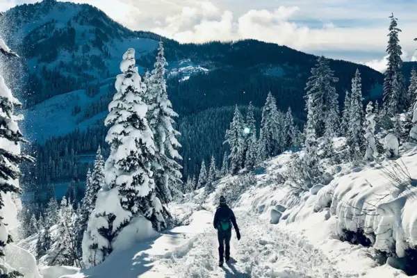Winterwandern Bad Gastein Eine Person geht auf einem verschneiten Pfad durch verschneite Berge.