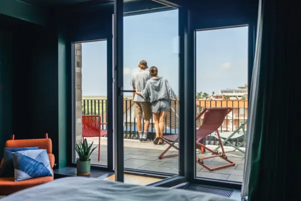 Balkon Ein Paar steht auf einem Balkon und schaut aus einem Fenster.